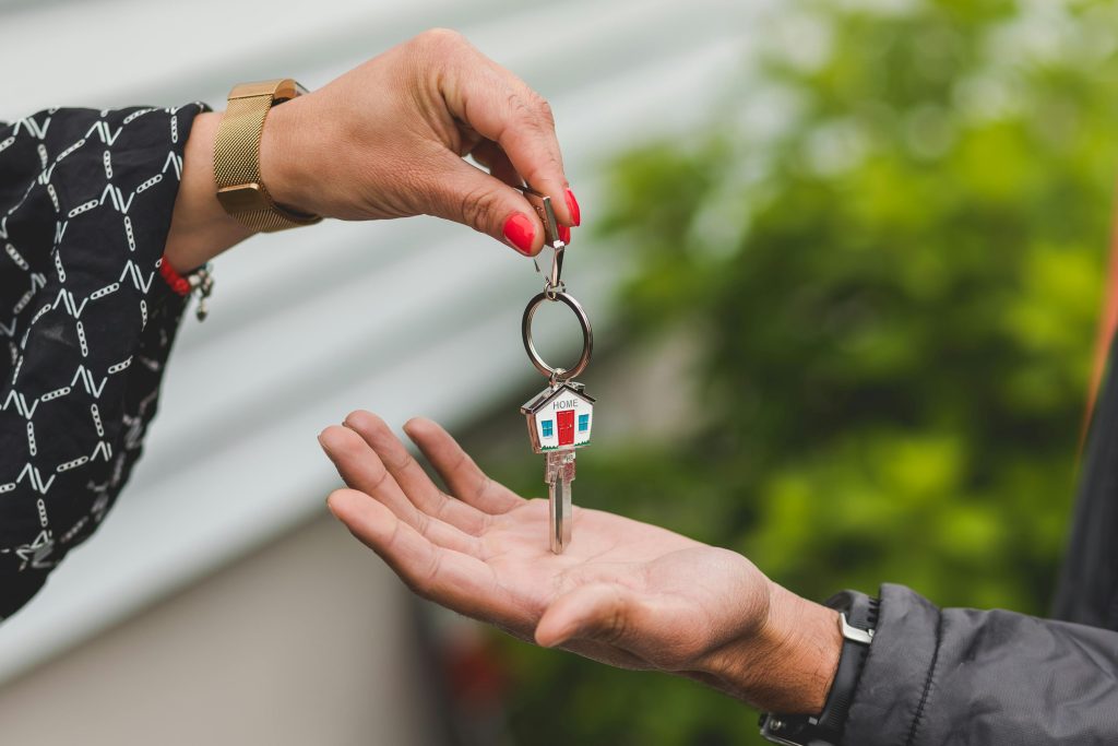 Une personne donne les clés d'une maison à une autre personne.